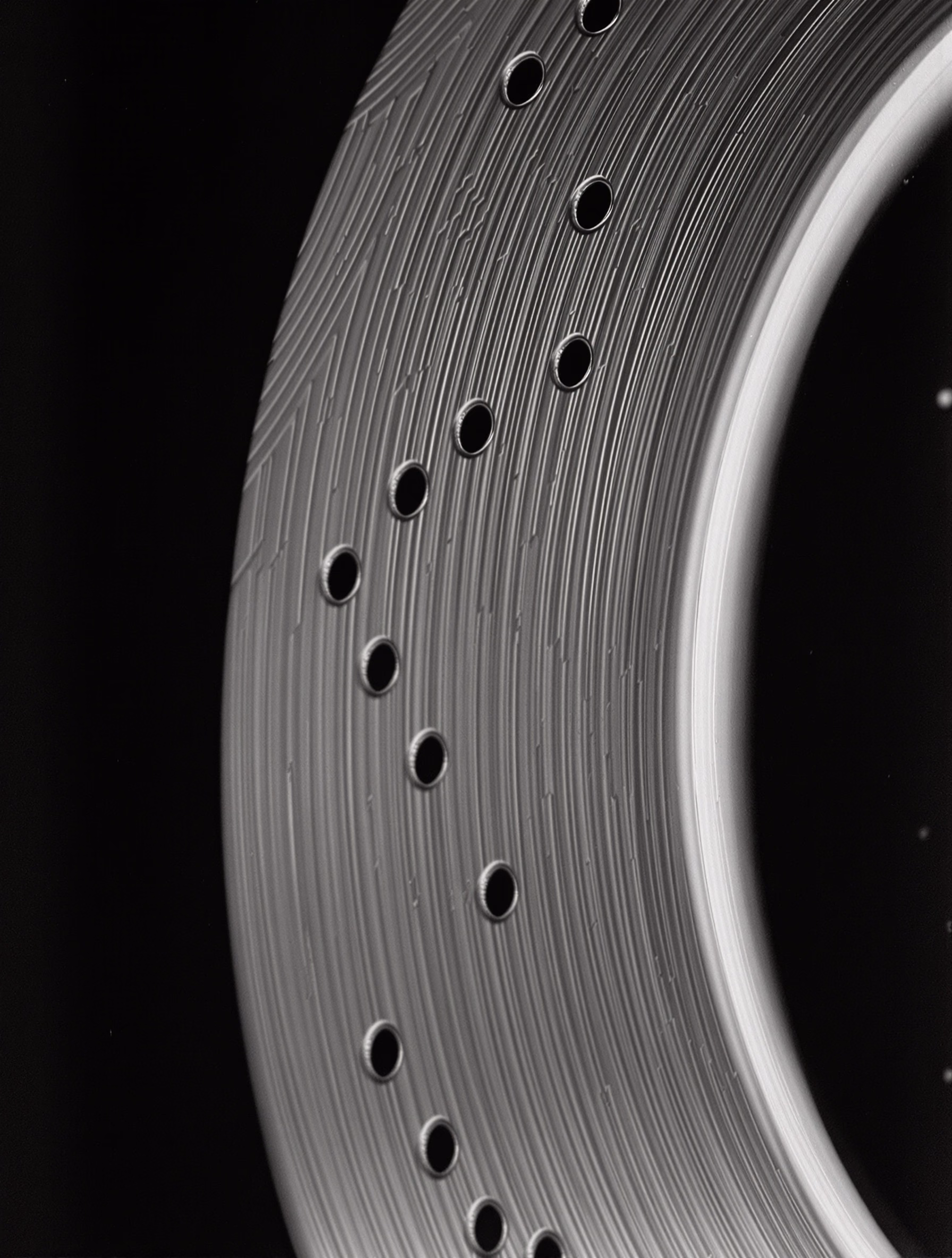 A carbon-ceramic brake rotor arc against pure black.
